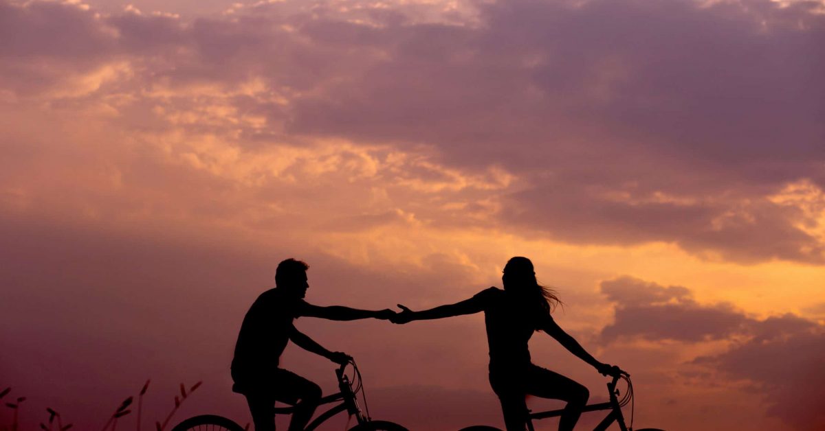 A couple rides bicycles on sunset