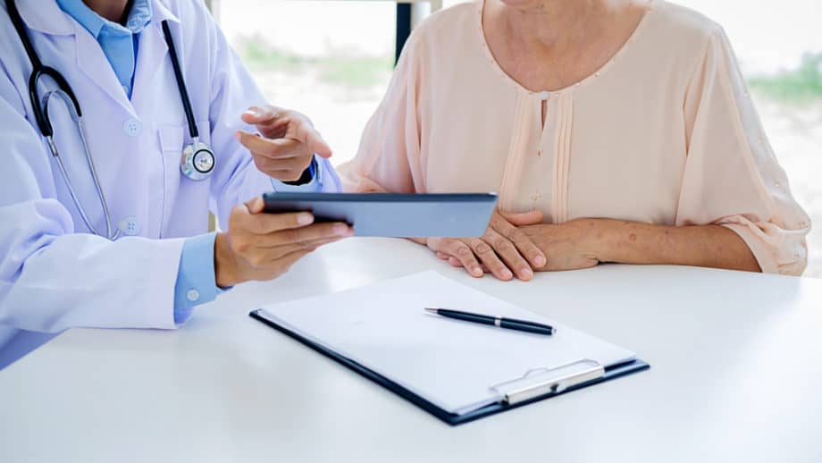 Doctor and patient discuss information on a tablet.