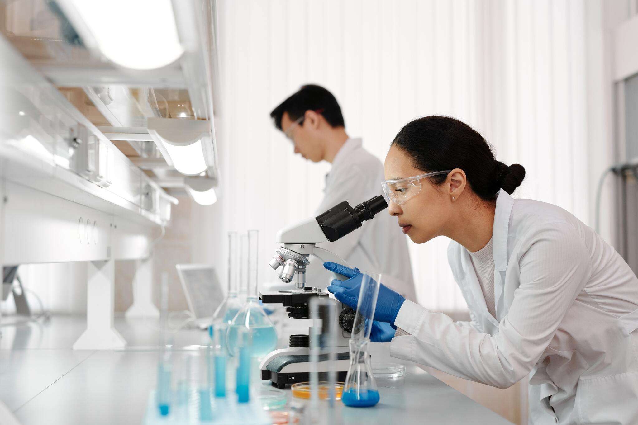 A woman in the laboratory looking into a microscope