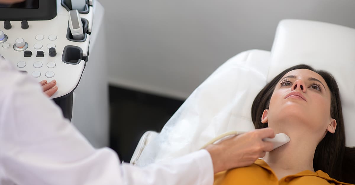 Ultrasound specialist at work. Female doctor making ultrasound thyroid gland test to female patient