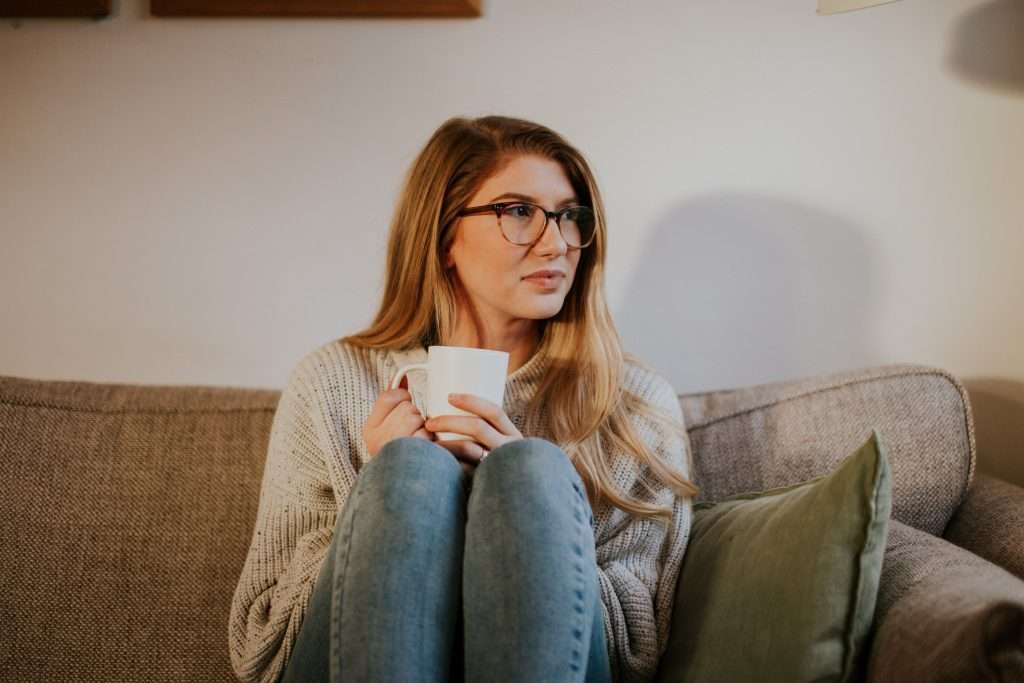 A woman is sitting while holding a cup